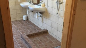 A bathroom with two sinks, a mirror, and a shower. - Peregrino Vendégház (Budaors)