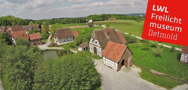 A rural village with traditional half-timbered houses, a small pond, and a clear sky. - Hotel Vogt (Bad Driburg)