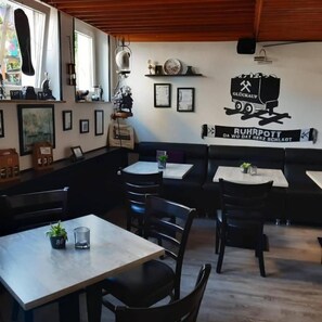 A restaurant interior with tables, chairs, and a wall with a truck and text. - Hotel Vogt (Bad Driburg)
