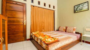 A bedroom with a wooden bed, a large window with curtains, a door, and a painting on the wall.