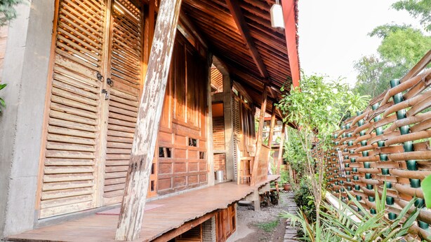 A traditional wooden building with a sloped roof and a wooden fence. - Lorong Homestay (Kasihan)