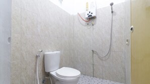 Een kleine betegelde badkamer met toilet, douche en een aan de muur bevestigd warmwaterboiler.