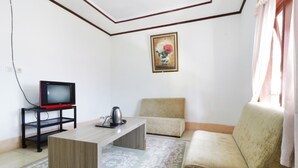 Een woonkamer met een bank, een salontafel en een televisie op een dressoir.