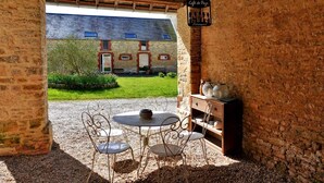An outdoor seating area with a table and chairs, a rustic brick wall, and a sign reading "Café de Pays." - Great Ancient Renovated with fireplace and billiards (isigny sur mer)