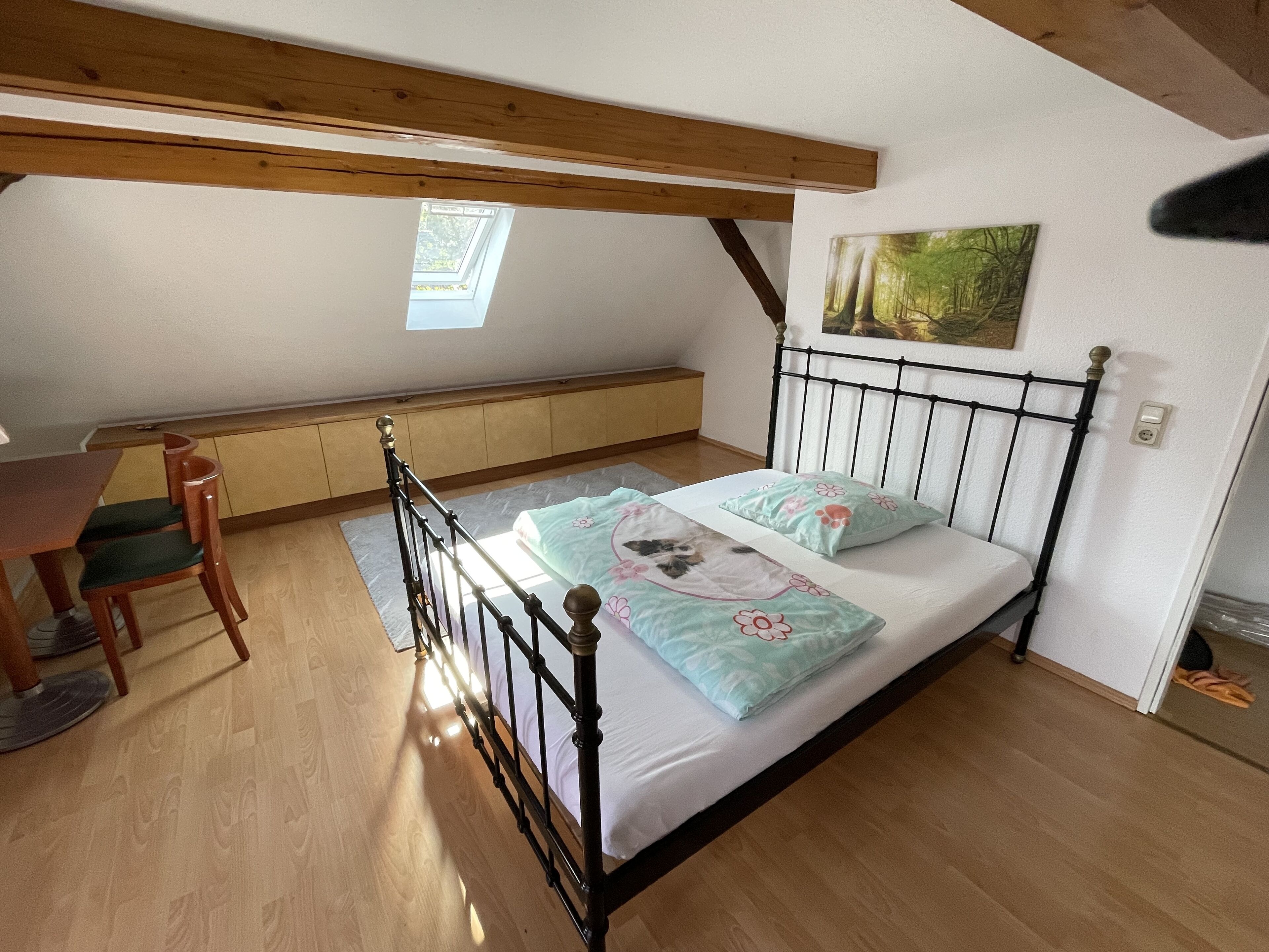 Un dormitorio con cama, escritorio y silla.
