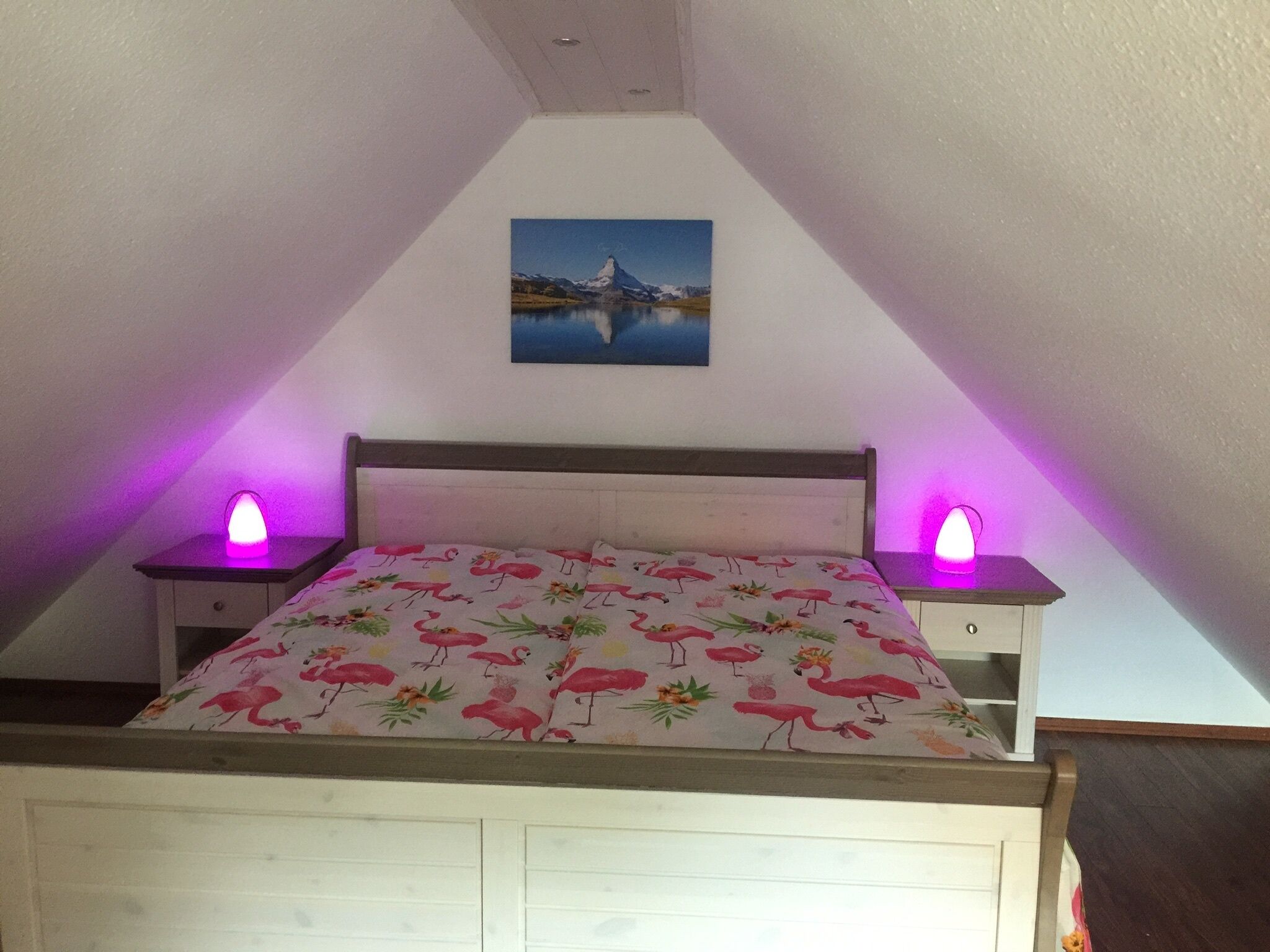 Un dormitorio con una cama, dos mesitas de noche y un cuadro en la pared.