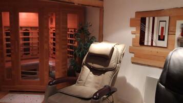 Une pièce comprenant un fauteuil en cuir beige, un meuble en bois doté de portes en verre et une œuvre d’art abstraite accrochée au mur.