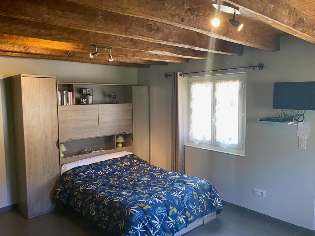 Un dormitori amb llit, armari encastat i finestra amb cortines.