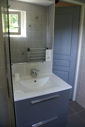 A bathroom with a white sink, a mirror, and a door. - Domisiladore (Latouille-Lentillac)