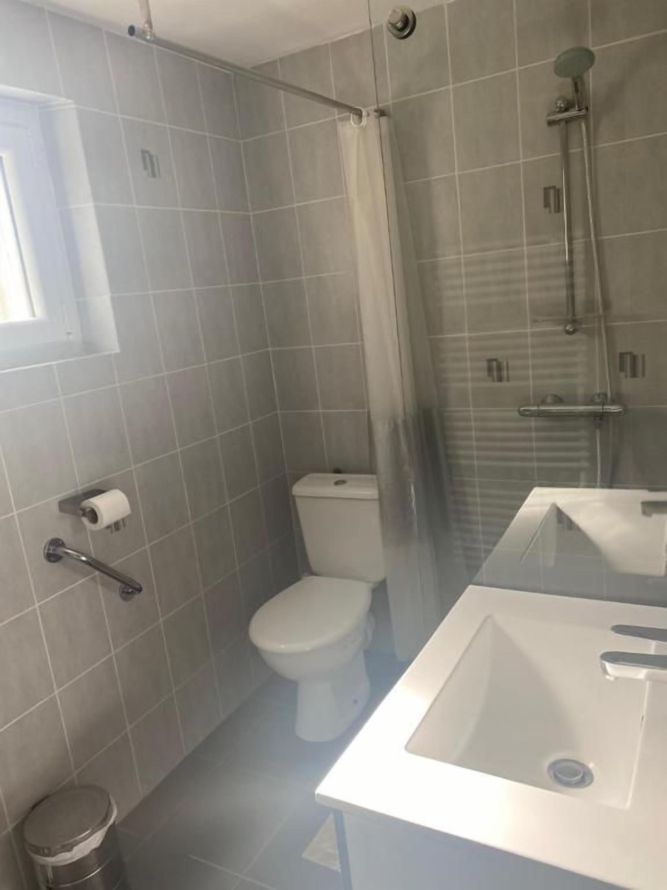Ein Badezimmer mit Toilette, Dusche und Waschbecken.