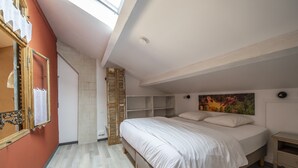 A bedroom with a bed, a nightstand, a wardrobe, and a painting on the wall. - Charming cottage in guest house on 6700m2 property, swimming pool, large garden (L'Isle-sur-la-Sorgue)