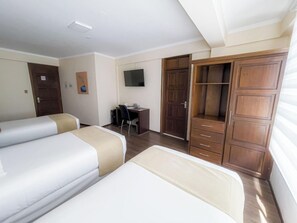 A hotel room with two beds, a desk, a TV, and a wardrobe. - Hotel Boutique Domani (Cochabamba)