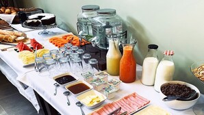 A buffet table with various food items, condiments, and beverages. - Hotel Boutique Domani (Cochabamba)