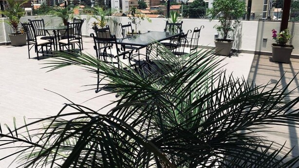 Una terraza en la azotea con muebles de exterior y plantas en macetas.