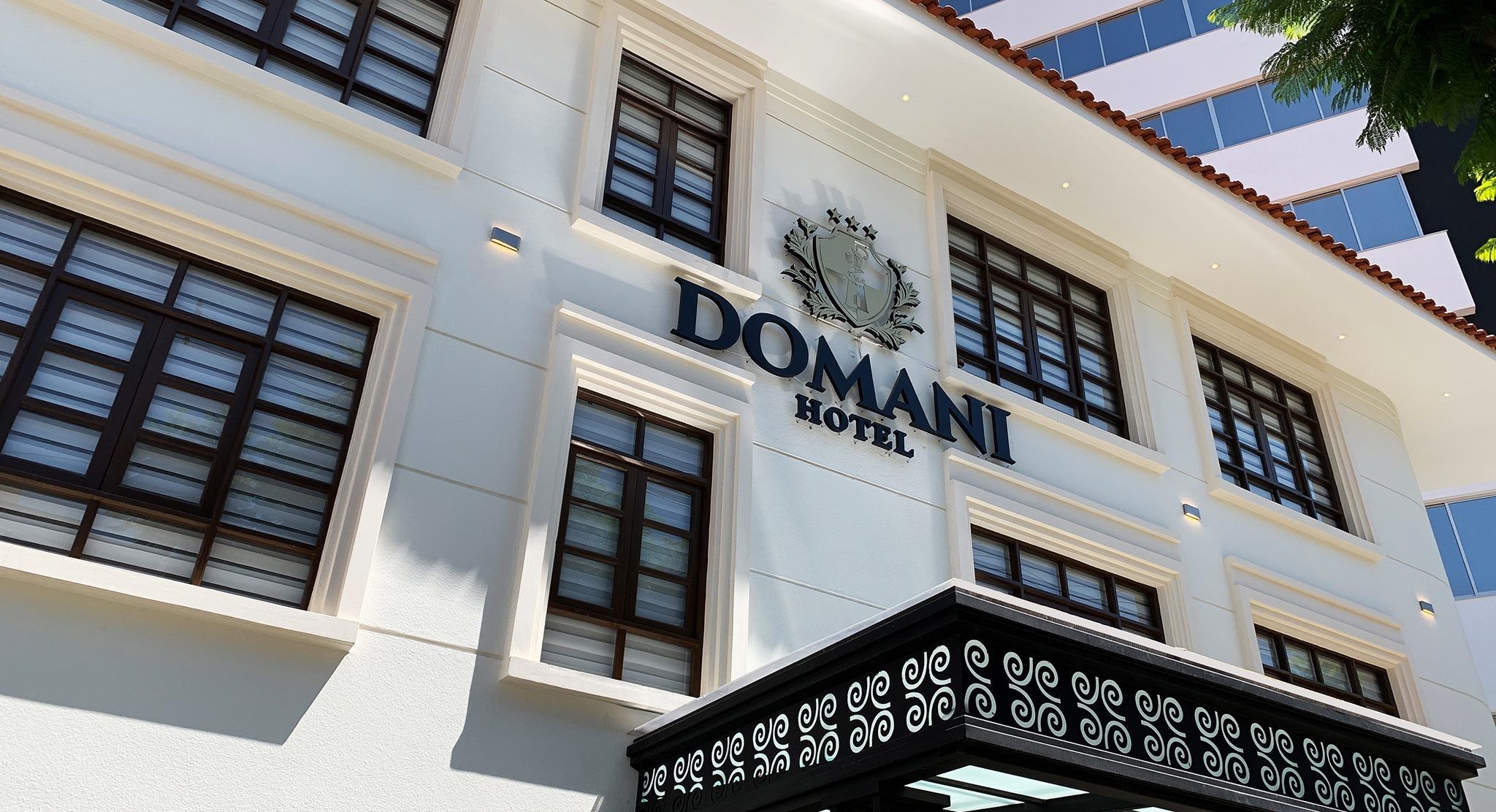 A building with a sign that reads 'DOMANI HOTEL.'