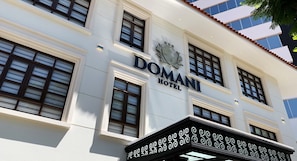 A building with a sign that reads 'DOMANI HOTEL.'