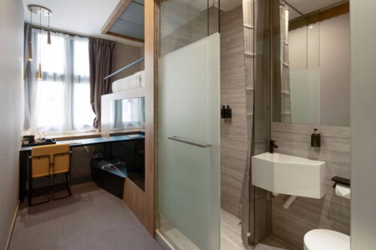 A modern bathroom with a glass shower enclosure, a sink, and a toilet.