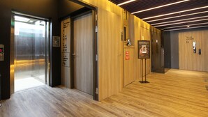 Um elevador moderno com visor digital e sinalização de hidrante.