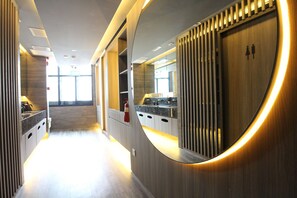 A modern kitchen with a curved mirror, wooden cabinets, and a built-in stove.