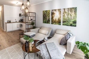 Un salon moderne avec un canapé, une table basse et une cuisine en arrière-plan.