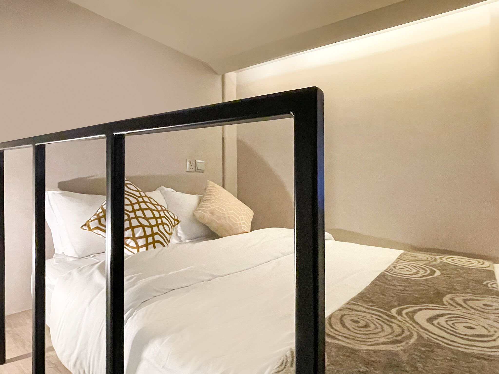 Ein Schlafzimmer mit einem Bett, Kissen und einem gemusterten Teppich.