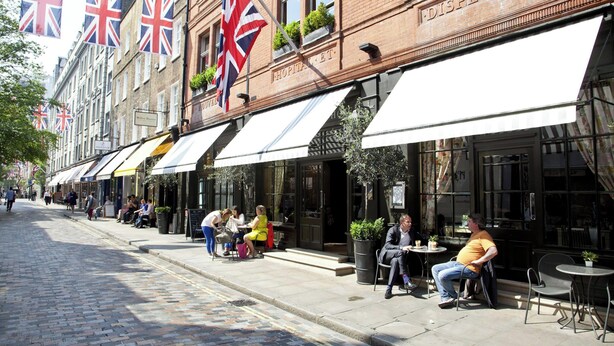 A street with outdoor seating at a restaurant with a sign reading "HOPITAL HOTEL". - Cockspur Street by Onefinestay (London)