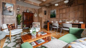 A cozy living room with a wooden ceiling, a dining area with a wooden table and chairs, and a green sofa. - Cockspur Street by Onefinestay (London)