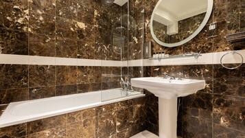 A bathroom with a bathtub, a sink, and a shower.