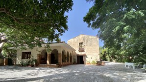A building with a courtyard, arched entrance, and potted plants. - Dimora Tana Pacenzia (Cefalù)