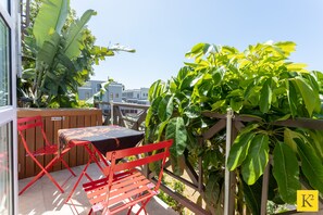 Relax in a serene outdoor space surrounded by lush greenery and city views.