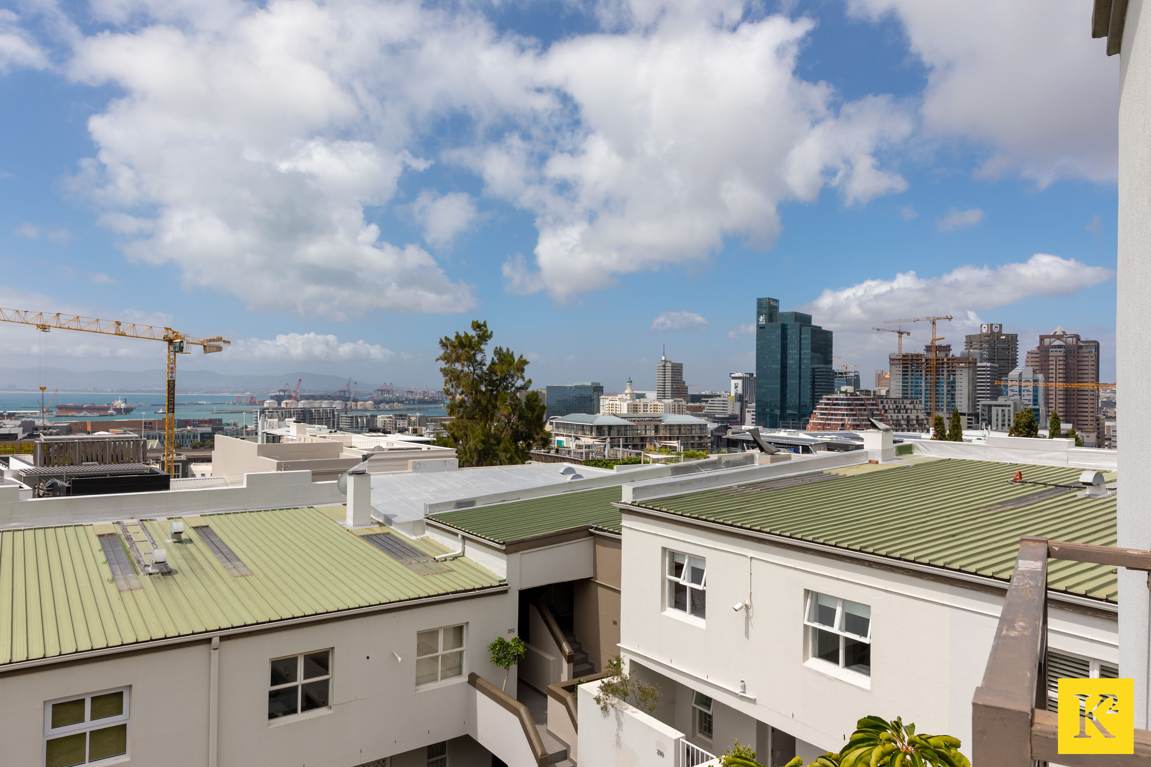 A cityscape with modern buildings, a construction crane, and a clear sky.