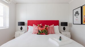 A hotel room with a large bed, two bedside tables, and a red headboard. - 209 De Waterkant Piazza (Cape Town)