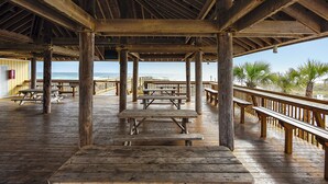 A wooden deck with picnic tables and benches overlooking a beach. - Pet friendly,  Water, Water Everywhere  SPC4210 (Destin)