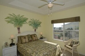 A bedroom with a bed, two nightstands, a chair, a ceiling fan, and a window with a view. - Pet friendly, Water, Water Everywhere SPC4210 (Destin)