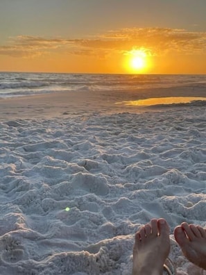 A beach scene with waves and a sunset in the background.