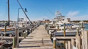 A wooden pier leading to a marina with various boats docked. - Pet friendly,  Water, Water Everywhere  SPC4210 (Destin)