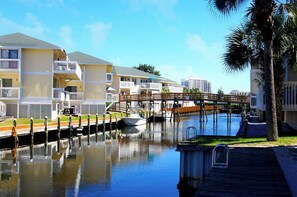 A waterfront hotel with multiple balconies, a dock, and a pool area. - Pet friendly, Water, Water Everywhere SPC4210 (Destin)