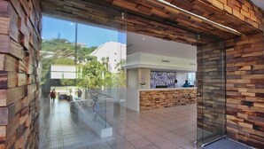 Un espace d’accueil agrémenté d’un mur en bois, d’une entrée en verre et d’un sol carrelé.