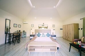 A spacious bedroom with a large bed, bedside tables, a desk, and a wardrobe. - La Casa Denika (Puerto Princesa)