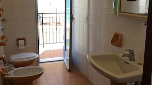 A bathroom with two toilets, a sink, and a mirror. - Apartaments Cavour 4 (Cefalù)