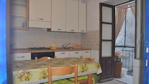 Una cocina compacta con una mesa de comedor, armarios y una ventana pequeña.