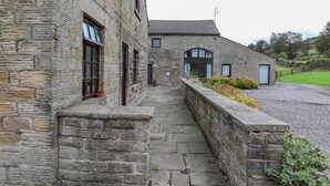 Un edificio de piedra con un camino de piedra que conduce a una entrada con portón.