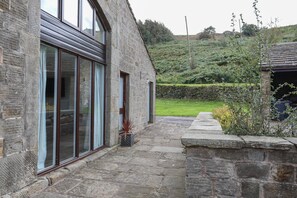 A stone building with large windows and a stone pathway leading to a green lawn. - Foxholes Farm (Sheffield)