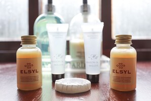 A set of ELSYL conditioner bottles and a bar of soap on a wooden surface. - Foxholes Farm (Sheffield)