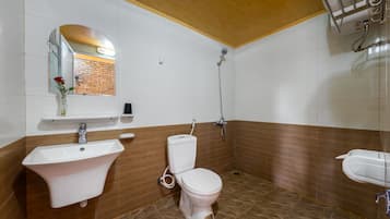 A bathroom with a white sink, a toilet, and a shower.