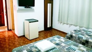 A room with a bed, a television, a small refrigerator, and a window with curtains. - Hotel Turistico de Alagoinhas (Alagoinhas)