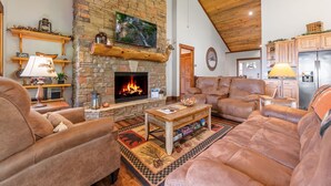 A cozy living room with a stone fireplace, leather sofas, and a wooden ceiling. - A Mornings Mist - Morganton, GA (Morganton)
