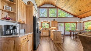 A spacious kitchen with wooden cabinets, a large island, and a dining area with a table and chairs. - A Mornings Mist - Morganton, GA (Morganton)