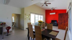 A dining area with a table, chairs, and a ceiling fan. - Beach house in Panama city Punta Barco Viejo (Panamá)