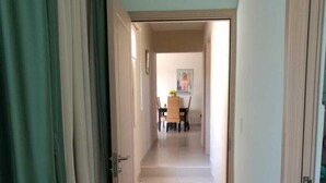 A hallway with a dining area at the end, featuring a table and chairs. - Beach house in Panama city Punta Barco Viejo (Panamá)